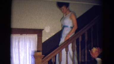1969: a young woman walking down a staircase, perhaps in her prom dress DILLER