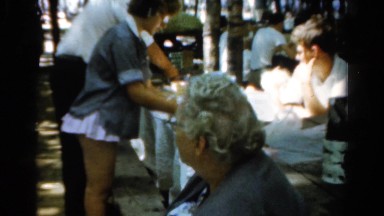 1954: Man and Woman Processing Cloth on Table in Breezy Ohio Day