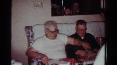 1954: family celebrating birthday of a grandfather he is unwrapping his present