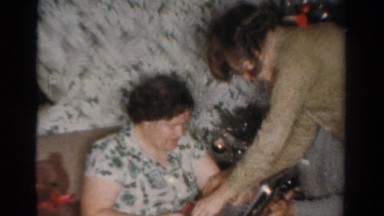 1954: a woman opens her present during the holidays. OHIO