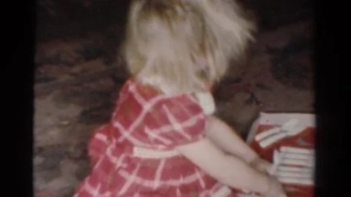 1954: a young girl on the floor opening a christmas gift OHIO