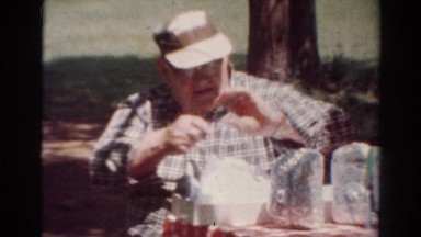 1954: Old Man in Plaid Shirt Laughing at Table During Ohio Picnic