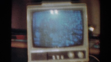 1954: a portable television sitting on furniture plays next to a christmas tree