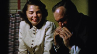 1956: a man aggressively taking a bite out of a sandwich as a woman watches