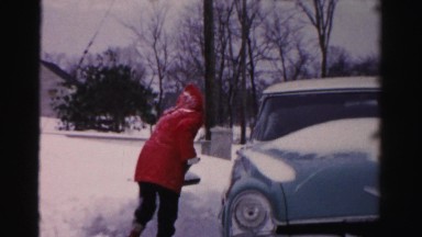 1956: someone in a red jacket shoveling snow from the driveway NEW YORK