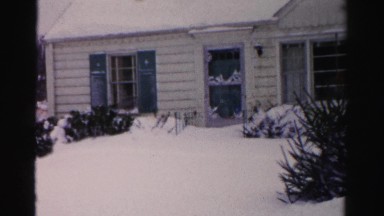 1956: a man shoveling snow outdoor one of many houses covered