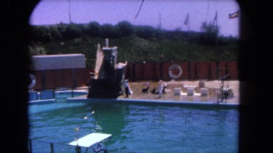 1962: people walking seals mounting platforms deck of large pool at sea life