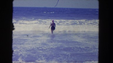 1962: woman walking through ocean waves SAN PEDRO, CALIFORNIA