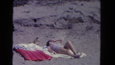 1962: a woman is sunbathing out in the middle of nowhere in the desert