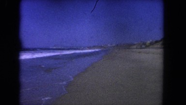 1962: a view of the beach and coastline and people playing in the surf