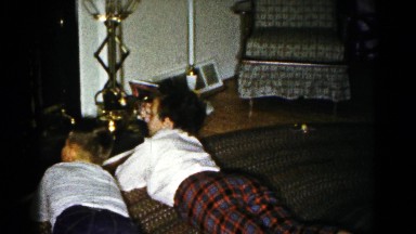 1959: two little boys lie in front of a lit fireplace on a cold day. HAGERSTOWN