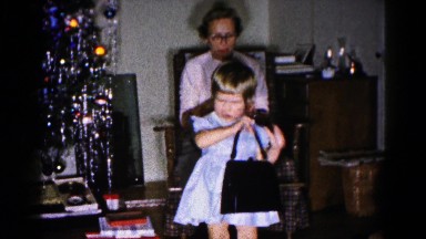 1959: 1960s family with child in smocked ruffle dress and christmas gifts
