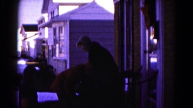 1959: a family on the front porch of a house bundling up for the cold weather
