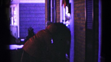 1959: two women dressed in heavy coats and mittens work on the front porch