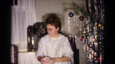 1959: child at home opening a christmas gift HAGERSTOWN, MARYLAND