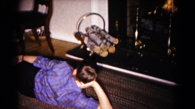 1959: boy reclining on floor watching holiday fireplace display HAGERSTOWN