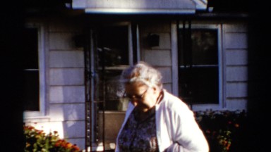 1962: Two Elderly Women Walk Out a Narrow Door One After the Other