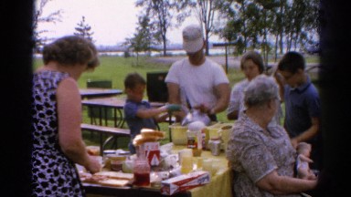 1962: a family gathered outdoor around a table in a park for a picnic CATSKILL