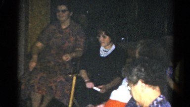 1962: women sit in chairs in a semicircle as a girl brings them presents