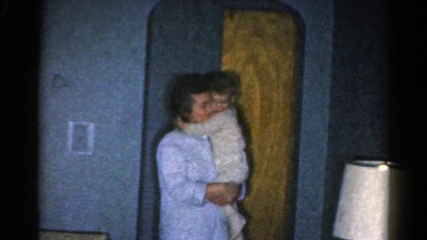 1962: mother dressed in nightgown carries and soothes toddler in pajamas