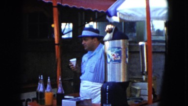 1951: a man standing behind a booth or stand eating an icy treat CLEVELAND, OHIO