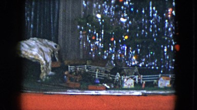 1951: miniature train moving on a railroad under a rotating christmas tree