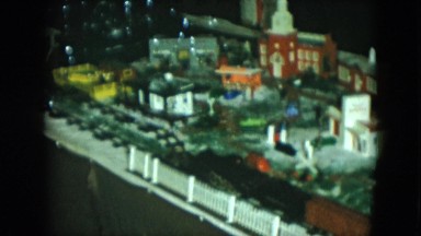 1951: toy train winds its way around a miniature town set on a table