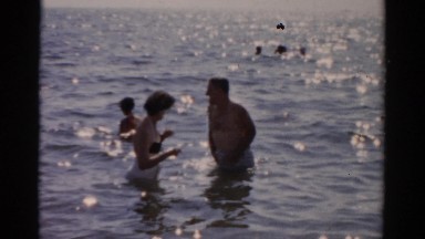 1957: man and woman wading in water on sunny day at beach CATSKILL, NEW YORK