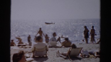 1957: many people sunbathing on beach on sunny summer day CATSKILL, NEW YORK