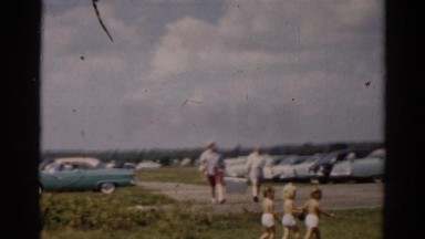 1957: two men carrying a large cooler through a parking lot CATSKILL, NEW YORK