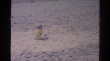 1962: boy sitting down digs up sand CATSKILL, NEW YORK