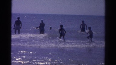 1962: adults and children wading in surf on a sunny day CATSKILL, NEW YORK