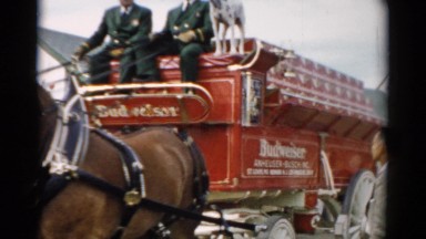 1957: budweiser advertised on a carriage pulled by horses during a parade