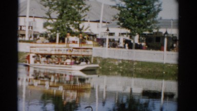 1957: a small boat packed with passengers navigating nearby shore CATSKILL