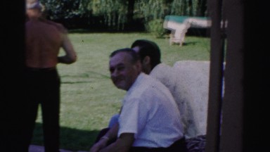 1957: older men gathered outdoor as a shirtless man works in the yard CATSKILL