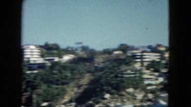 1962: homes in the hills and two people swimming in the ocean MEXICO