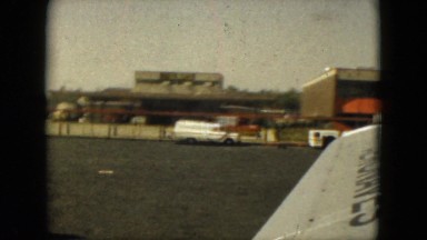 1962: a busy airport as seen from over a large metal wing of an airplane MEXICO