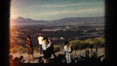 1967: A Group of People Taking Photographs at a Wide Valley with Mountains