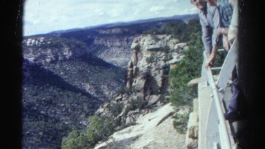 1967: people are leaning over a rail perilously looking a view of a rocky canyon