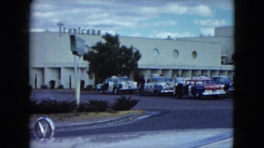 1959: Landmark Office, Parked Cars, Man Standing Near Lamp Post, Trees, Roads