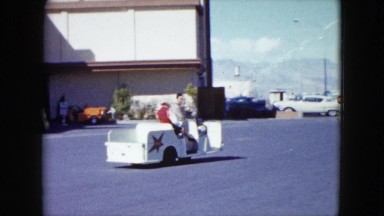 1959: a man driving a woman on a little cart through what appears to be a studio