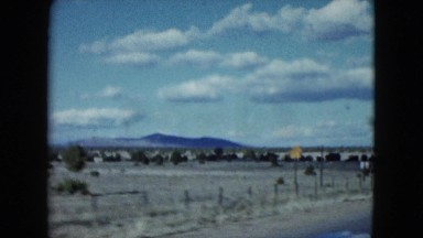 1959: View from a Moving Vehicle of Wide Plains with Mountains and Trees in the