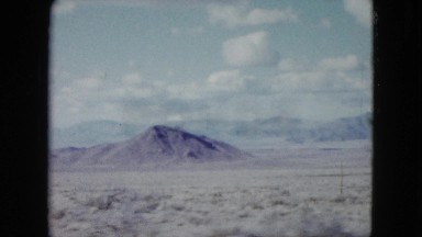 1959: view from a moving car of desert, mountains, the unending open road ahead