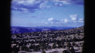 1959: vast arid land with sparsely distributed trees and mountain range ARIZONA