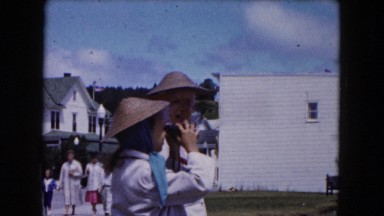 1961: Two Girls Wearing Woven Oriental Hats Taking Turns Looking Through Binoculars