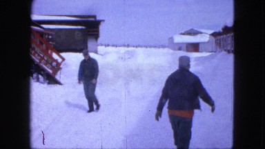 1963: Two Men Walking Happily in Opposite Directions on Snow-Covered Street