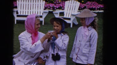 1961: a woman outdoor, handing a drink to a small girl in a hat MINNESOTA