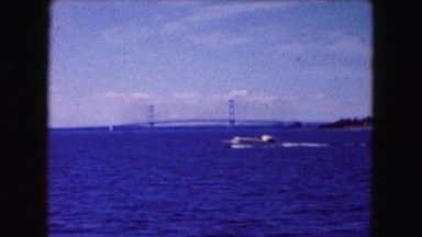 1961: boat speeding through the choppy blue water along the golden gate bridge