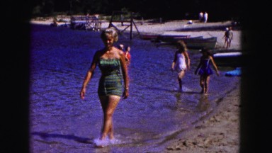 1961: young woman enjoying herself at the beach followed by kids MINNESOTA