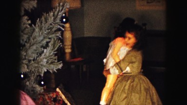 1961: two girls with mother getting dolls in front of the christmas tree
